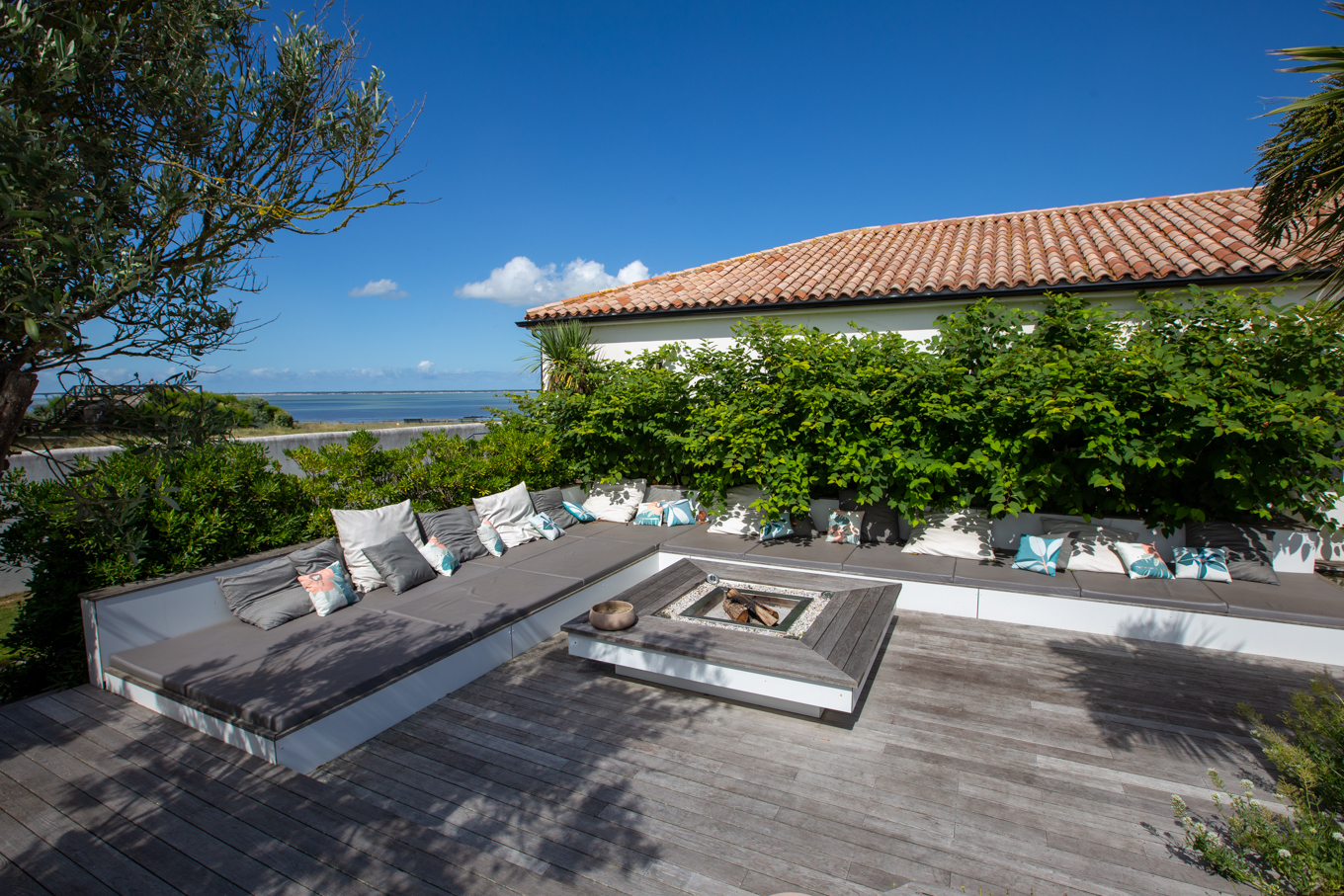 Terrasse arrière de la villa 180° mer et son salon d'extérieur autour du brasero