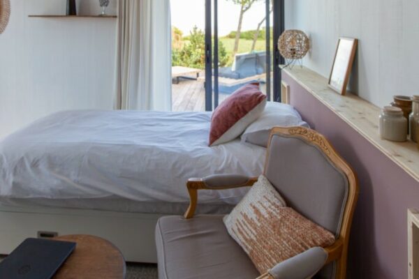 Chambre modulable avec vue sur mer et accès double à la terrasse décorée dans les teintes rosées des marais salants