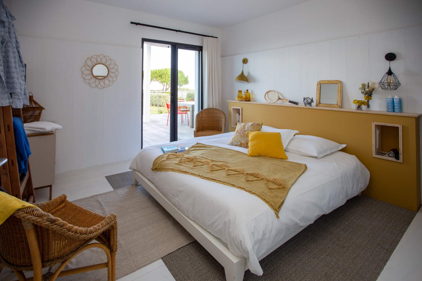 La chambre Immortelle des dunes avec son lit king size, ses tons jaunes et son accès terrasse direct