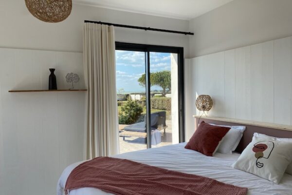 La chambre Sel Marin avec ses tons roses, son lit double modulable et son accès direct à la terrasse